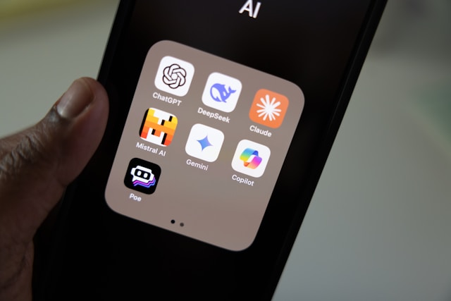 Smartphone showing AI apps including ChatGPT, Claude, DeepSeek, Gemini, and Copilot — the AI tools reshaping the cybersecurity threat landscape in 2026